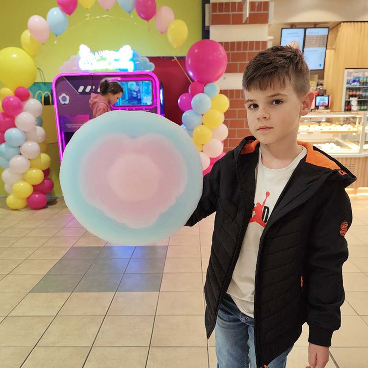 Children enjoying cotton candy from a vending machine