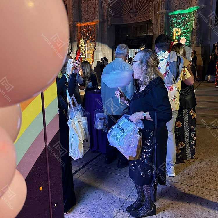 Busy amusement park with cotton candy machine in foreground