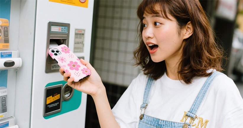 Customer using phone case vending machine to create custom design
