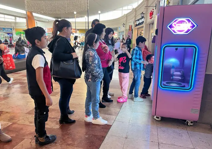 Technician performing routine maintenance on an automated cotton candy machine