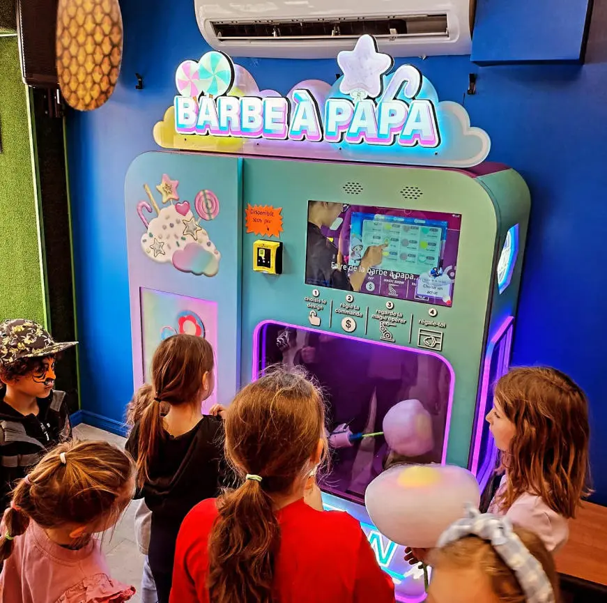 Persona que recibe un caramelo de algodón rosa recién hecho de una máquina expendedora