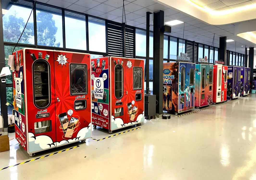 Person using touchscreen interface on a 2026 phone case vending machine with AR preview feature